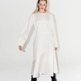 Udržitelné dámské bílé dlouhé šaty z organické bavlny s výraznými černými koženými botami.