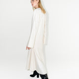 Udržitelné dámské bílé dlouhé šaty s dlouhým rukávem ADVA Studios z organické bavlny s výraznými černými kozačkami.