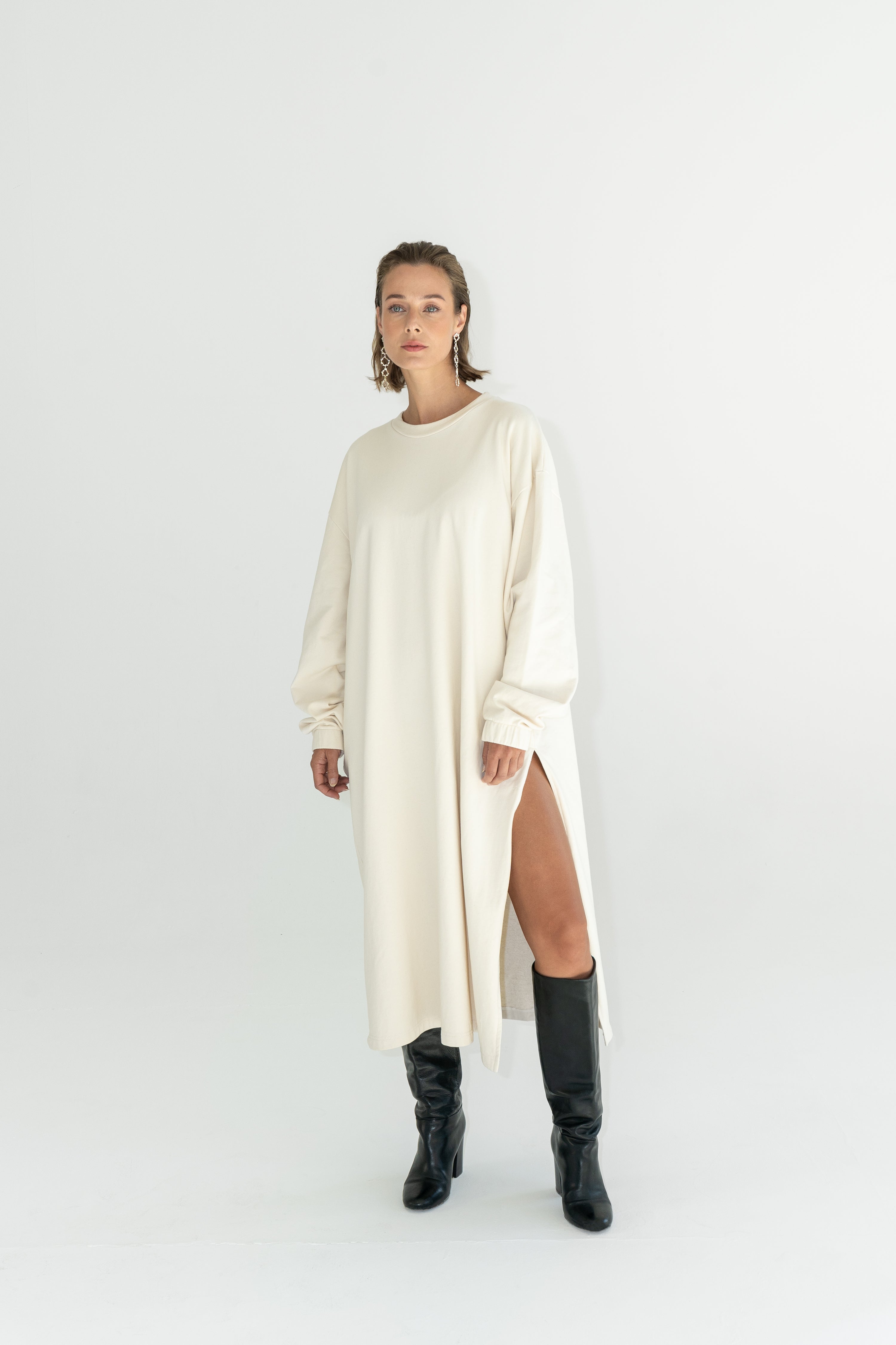Model in ADVA Studios oversized sweatshirt dress in offwhite color.