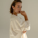 Model in oversized sweatshirt dress in offwhite color.