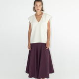 Modelka v sukni z organické bavlny ve vínové barvě a off-white vestě z merino vlny ADVA Studios.