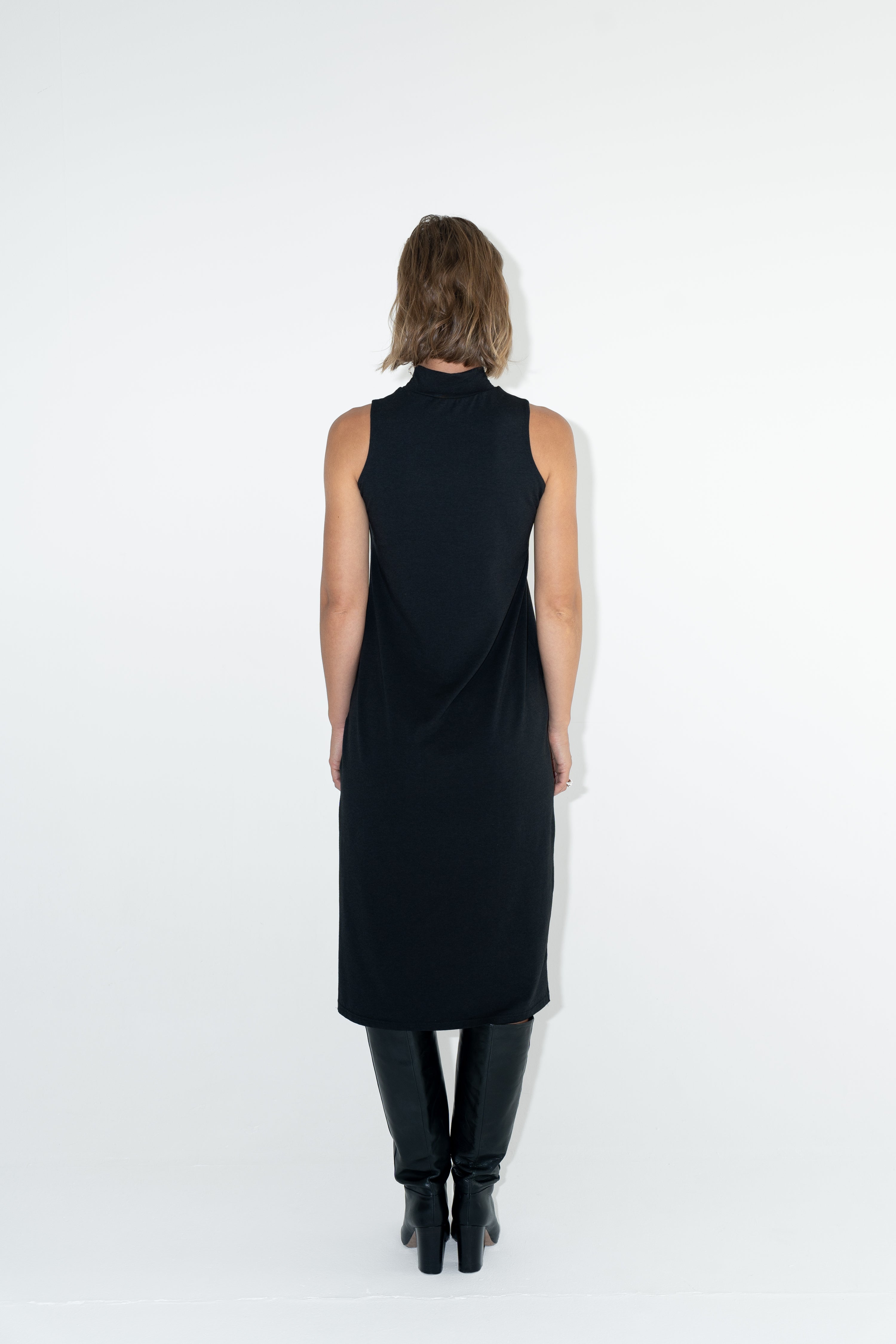Model in ADVA black turtleneck dress from back.