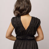 Detail černých řasených šatů ADVA Studios vyrobených z organické bavlny.