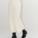 Dámská bílá sukně ke kotníkům z organické merino vlny s černými kozačkami. ADVA Studios