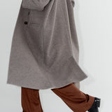 Dámský oversized dvouřadý kabát z organické vlny. Zimní Kabát Beyond Ordinary má dvouřadý oversized střih, čisté linie a výrazné knoflíky s hnědými širokymi kalhotami. ADVA Studios