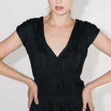 Detail černých řasených šatů ADVA Studios vyrobených z organické bavlny.