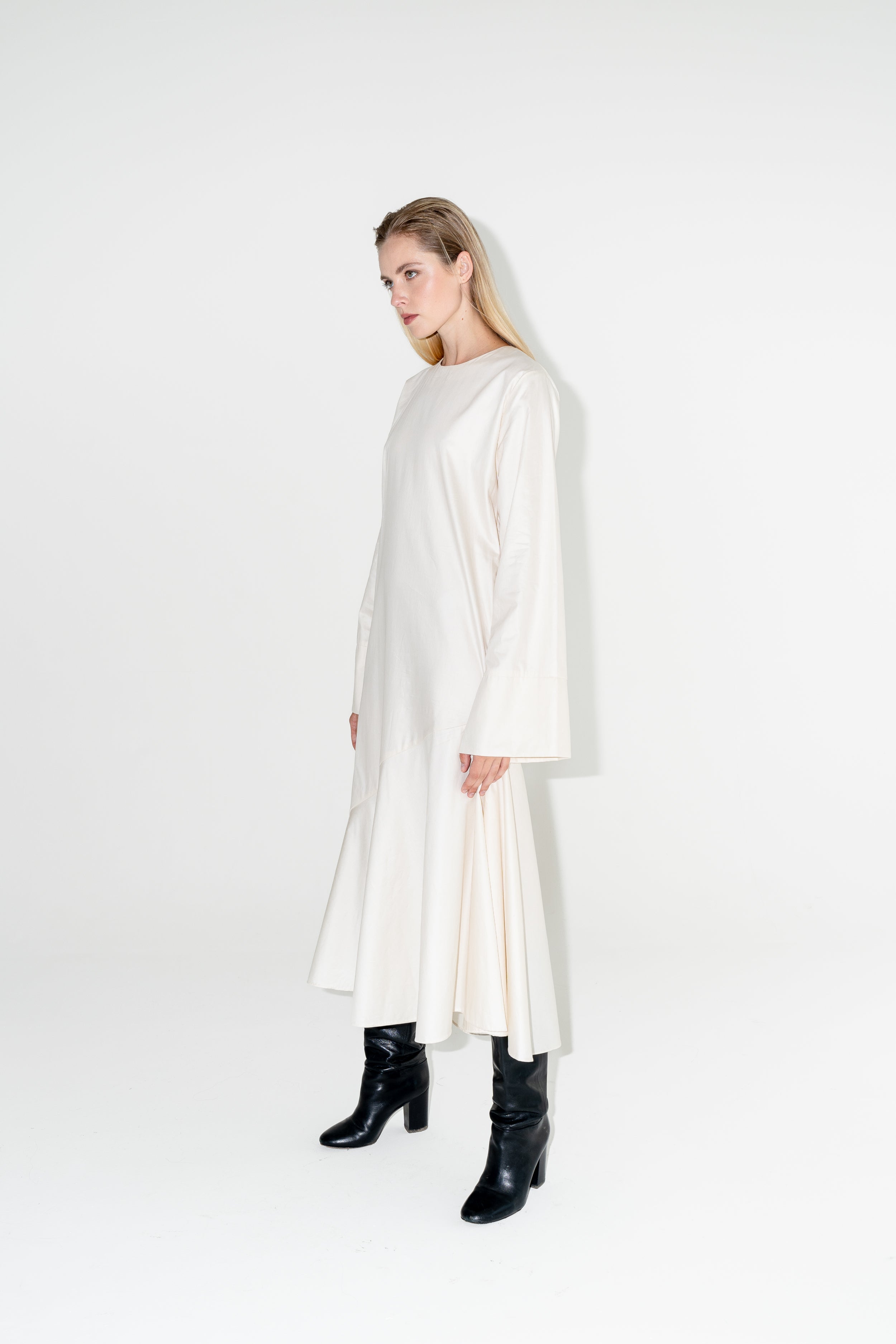 Dámské bílé dlouhé šaty ADVA Studios z organické bavlny s výraznými černými koženými botami.