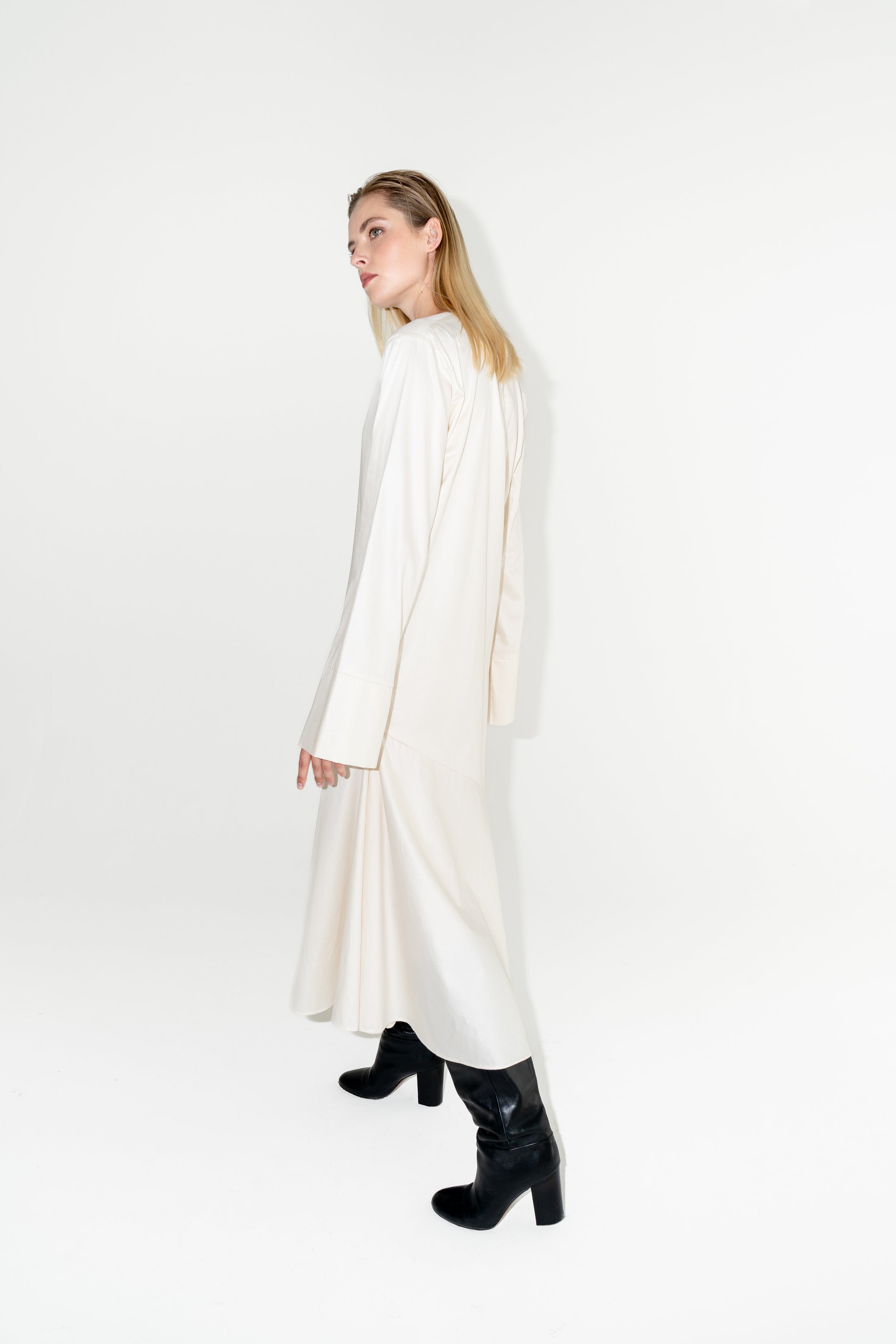 Udržitelné dámské bílé dlouhé šaty s dlouhým rukávem ADVA Studios z organické bavlny s výraznými černými kozačkami.