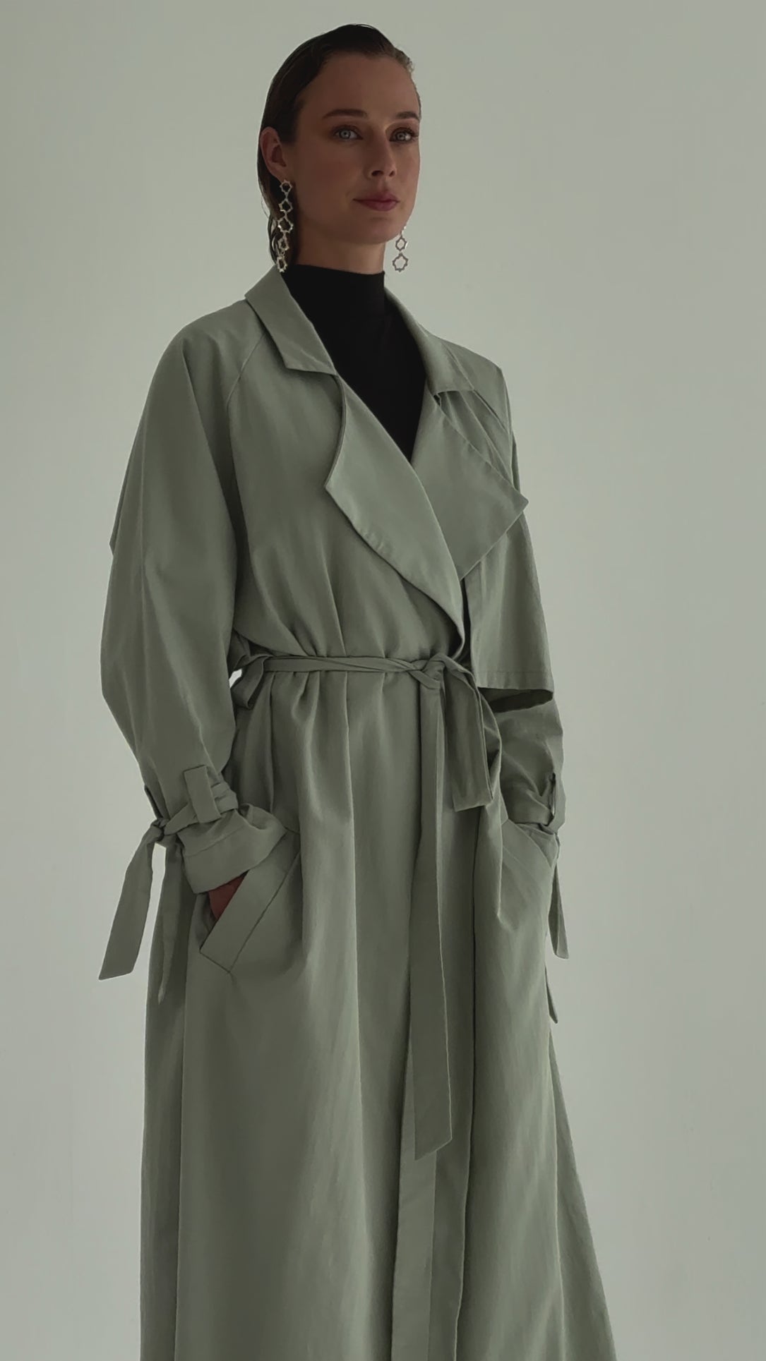 A model wearing an olive green trenchcoat